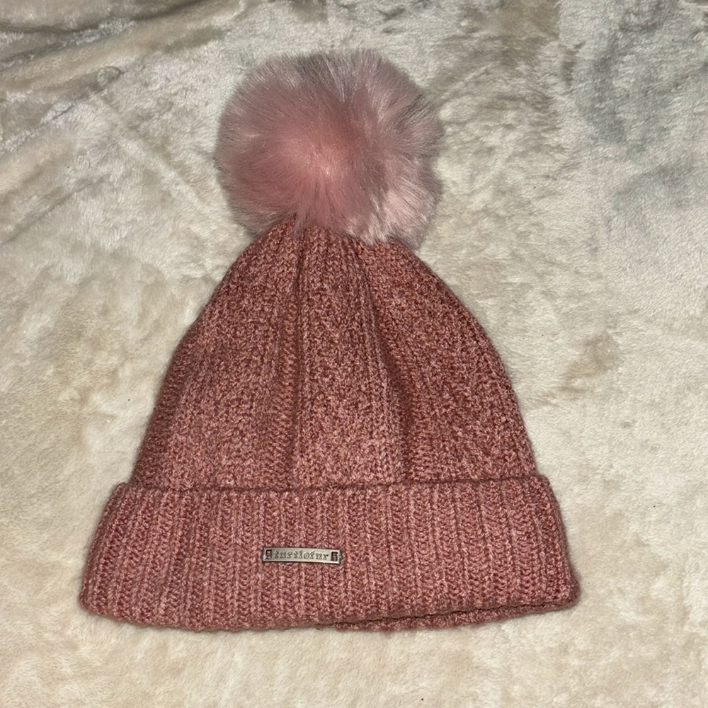 i’m selling a very cute beanie. it’s pink and has a soft fluffy ball on the top.